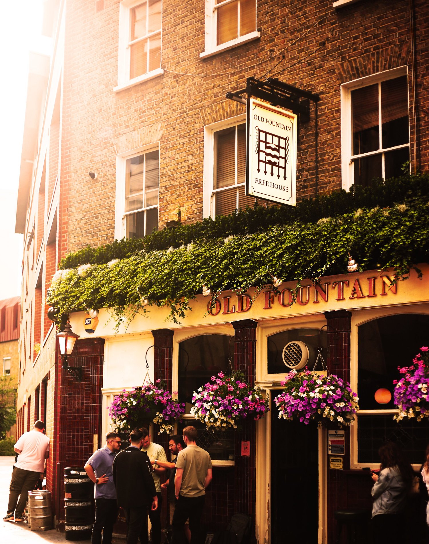 The Old Fountain frontage on Baldwin Street, with hanging baskets and the free house sign